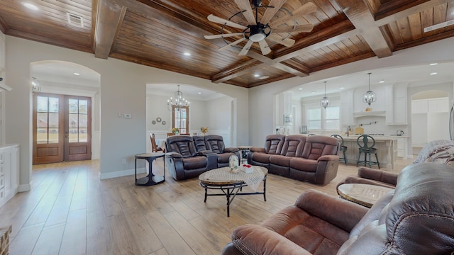 living room with wood ceiling, light hardwood / wood-style floors, beam ceiling, ornamental molding, and ceiling fan with notable chandelier