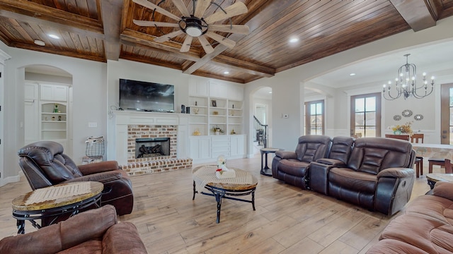 living room featuring built in features, light wood-type flooring, wood ceiling, and a brick fireplace