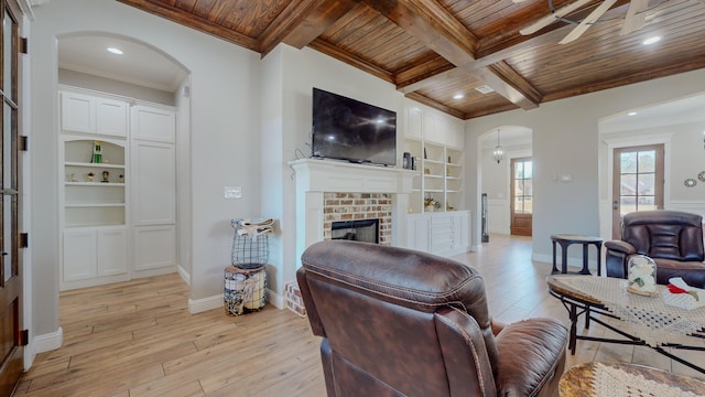 living room with beamed ceiling, a fireplace, light wood-type flooring, wooden ceiling, and coffered ceiling