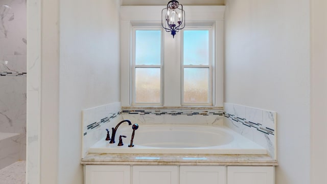 bathroom featuring a chandelier and separate shower and tub