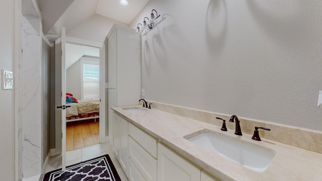 bathroom with tile patterned flooring, vanity, and vaulted ceiling