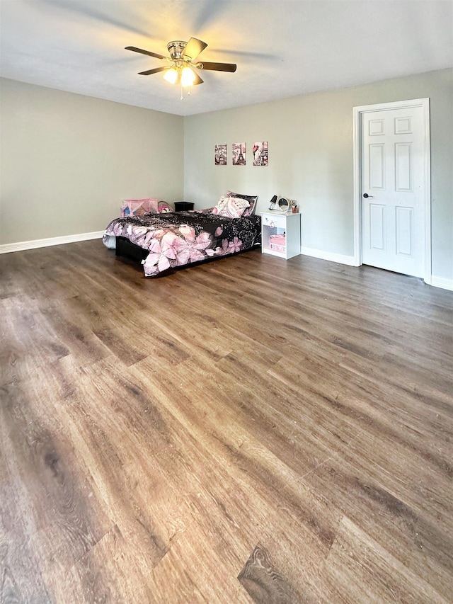 bedroom with dark hardwood / wood-style flooring and ceiling fan