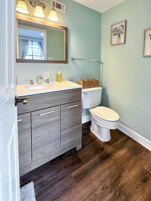 bathroom with hardwood / wood-style floors, vanity, and toilet