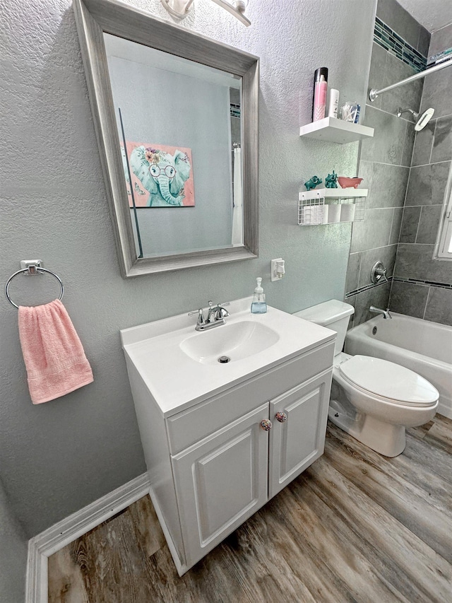 full bathroom featuring toilet, hardwood / wood-style floors, vanity, and tiled shower / bath