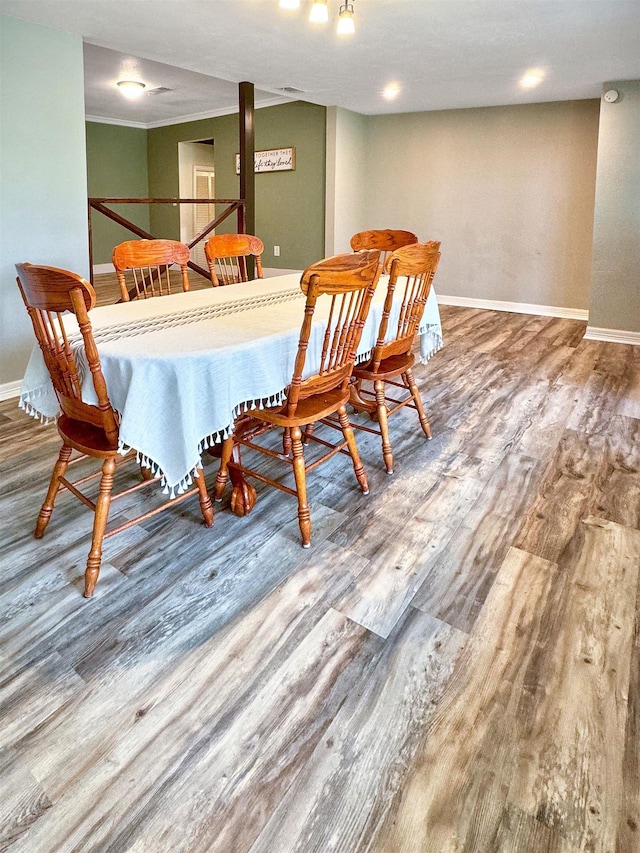 dining room featuring hardwood / wood-style flooring and crown molding