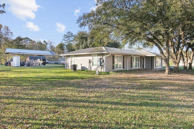 back of house featuring a yard, cooling unit, and a carport