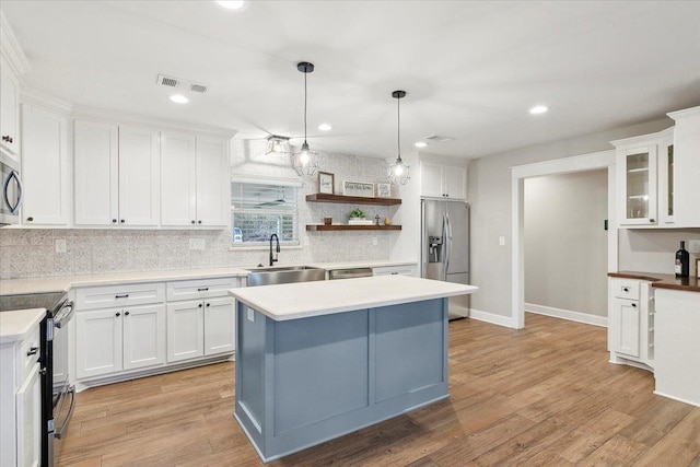 kitchen with white cabinets, stainless steel refrigerator with ice dispenser, black / electric stove, and sink