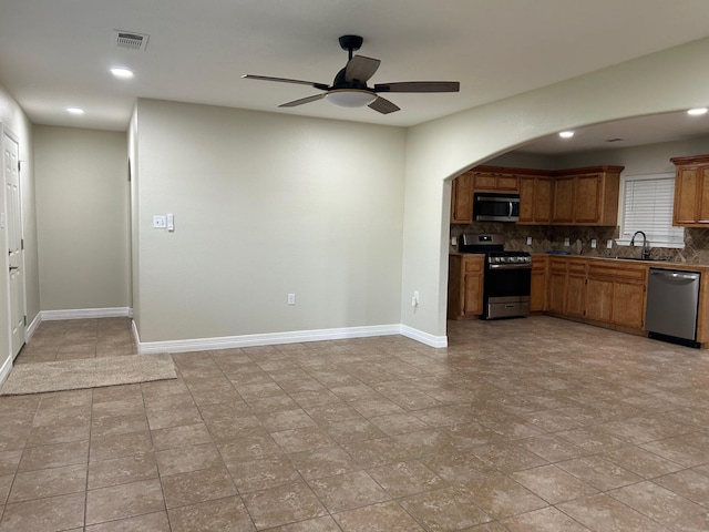 kitchen with ceiling fan, stainless steel appliances, tasteful backsplash, and sink