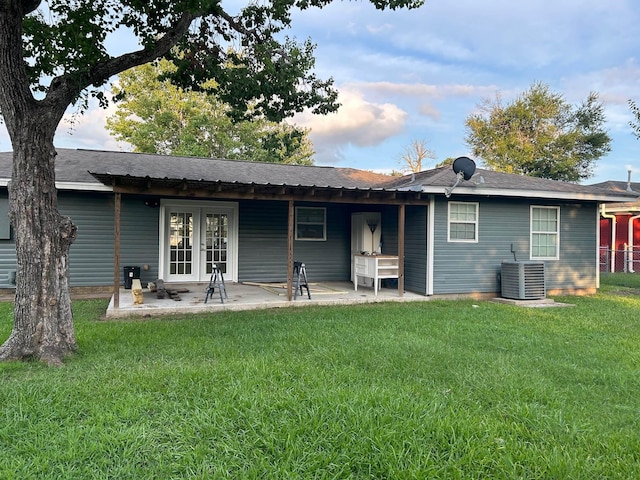 rear view of house with a lawn, cooling unit, and a patio area