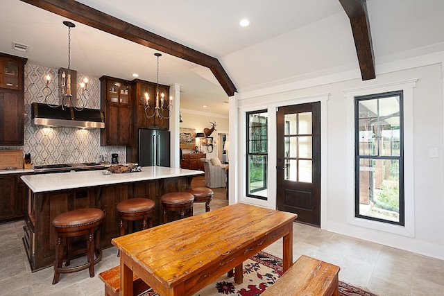 kitchen featuring pendant lighting, dark brown cabinets, a kitchen island, and stainless steel appliances