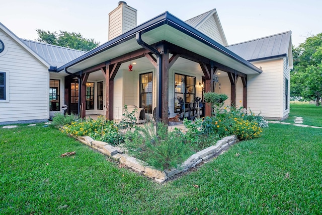 view of side of home with a yard and covered porch