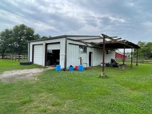 view of outbuilding featuring a garage and a lawn