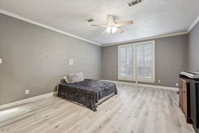 bedroom with light wood-style floors, baseboards, visible vents, and ornamental molding