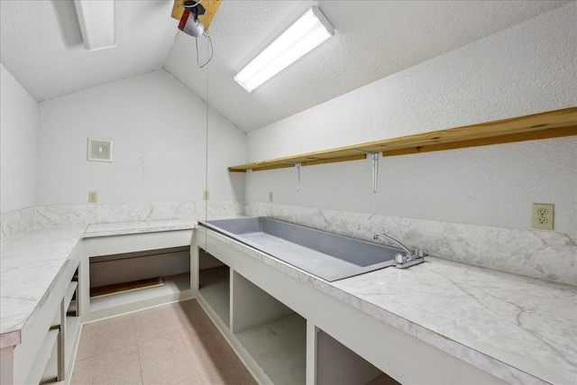 clothes washing area with a textured ceiling