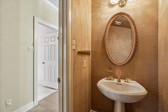bathroom with a textured wall and a sink