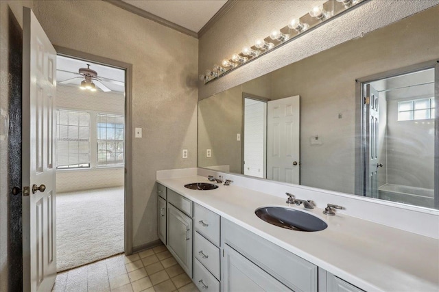 full bathroom with double vanity, crown molding, a ceiling fan, and a sink