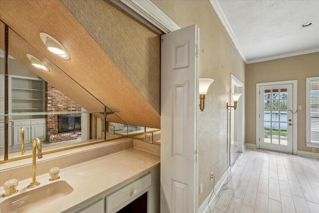 bathroom with built in features, crown molding, a textured ceiling, wood finished floors, and baseboards