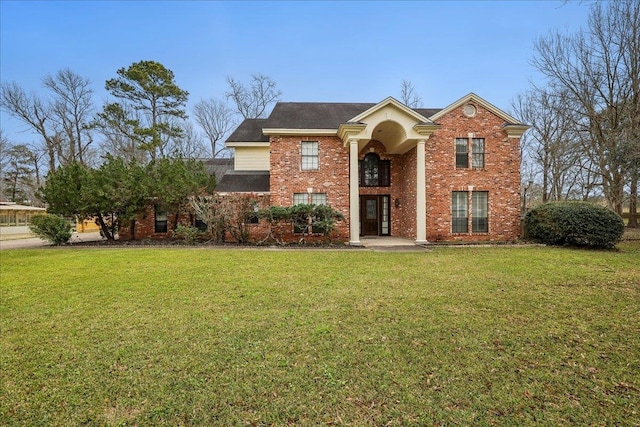 view of front facade with a front yard and brick siding