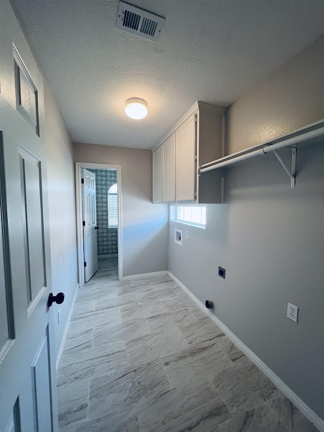 7060 Westgate Dr, Beaumont, TX 77706 - washroom featuring cabinet space, hookup for an electric dryer, hookup for a washing machine, baseboards, and a textured ceiling