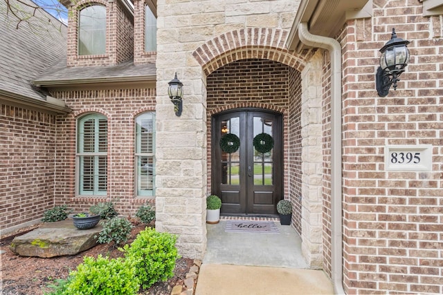 8395 Carrie Ln, Beaumont, TX 77713 - view of exterior entry with french doors, brick siding, and a shingled roof