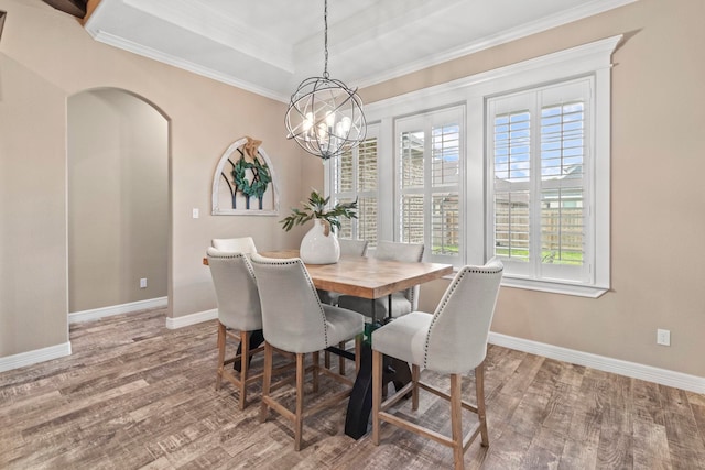 8395 Carrie Ln, Beaumont, TX 77713 - dining room with wood finished floors, a chandelier, crown molding, arched walkways, and a raised ceiling