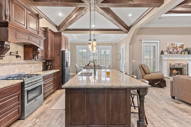 8395 Carrie Ln, Beaumont, TX 77713 - kitchen featuring stainless steel appliances, a breakfast bar, coffered ceiling, light wood-style flooring, and light stone countertops