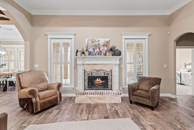 8395 Carrie Ln, Beaumont, TX 77713 - living room featuring arched walkways, wood finished floors, a brick fireplace, healthy amount of natural light, and ornamental molding