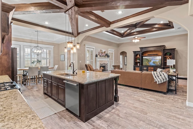 8395 Carrie Ln, Beaumont, TX 77713 - kitchen with a warm lit fireplace, a ceiling fan, dark brown cabinetry, coffered ceiling, and arched walkways