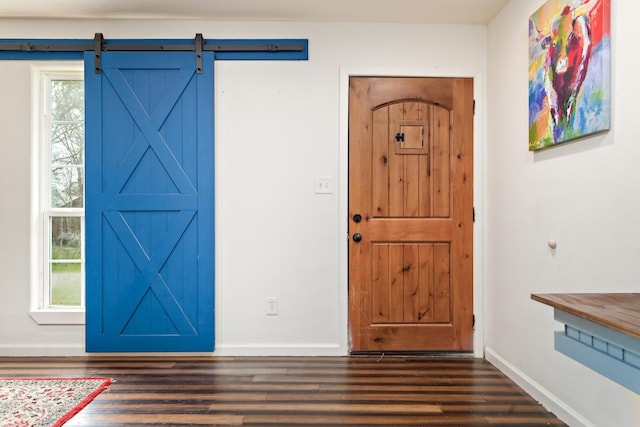 entryway with dark hardwood / wood-style floors and a barn door