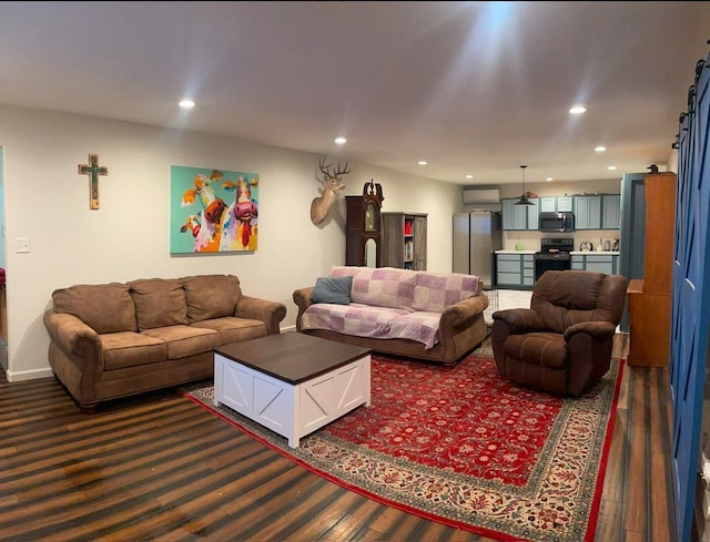 living room with dark hardwood / wood-style floors and a wall unit AC