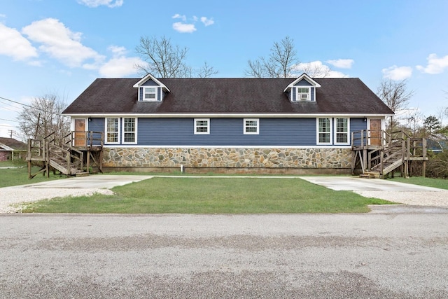 cape cod home featuring a wooden deck and a front lawn