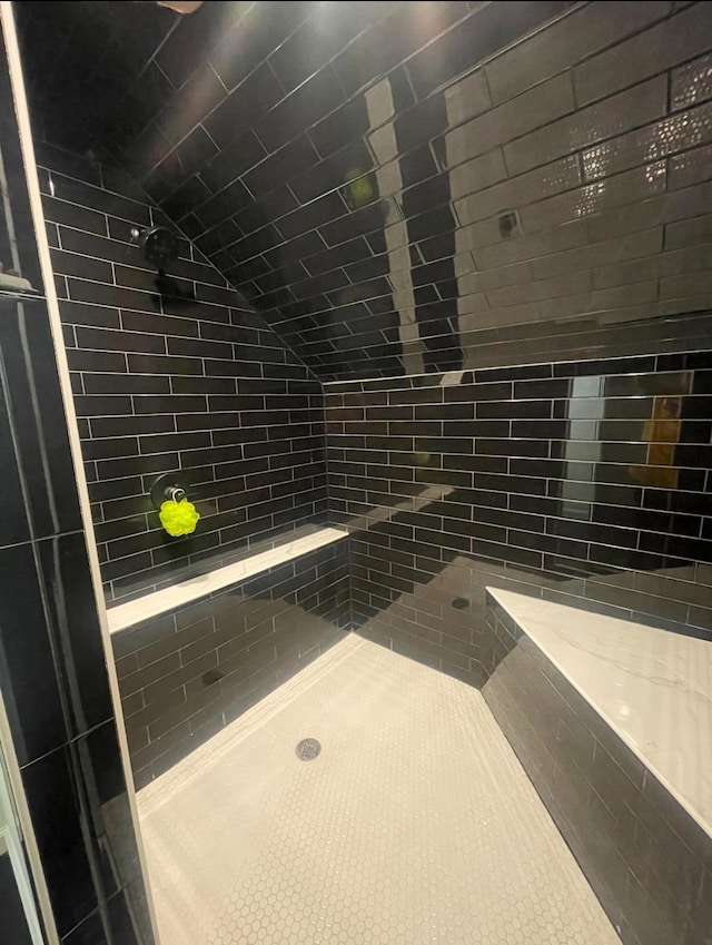 bathroom featuring tile patterned floors and a tile shower