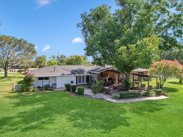 back of property with a patio area, french doors, fence, and a lawn