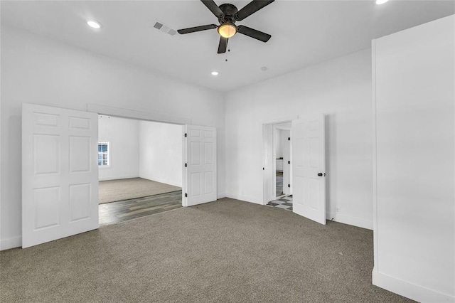 empty room featuring ceiling fan and carpet