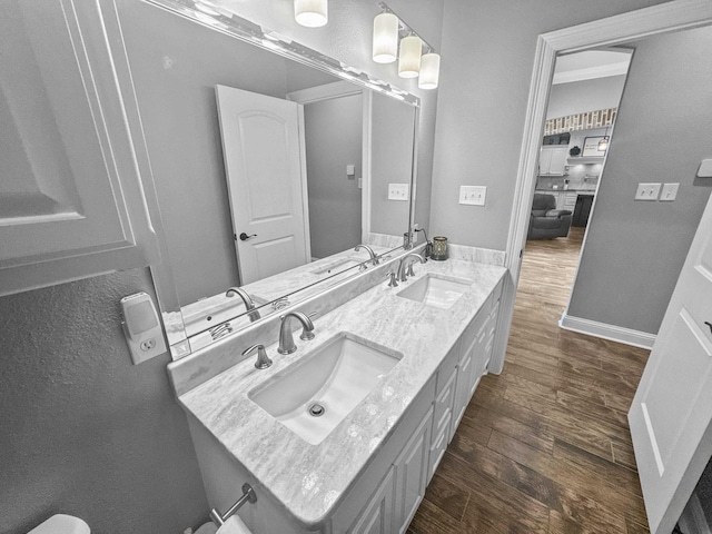 bathroom with wood finished floors, a sink, and baseboards