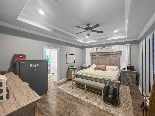 bedroom with baseboards, a raised ceiling, dark wood finished floors, ceiling fan, and crown molding