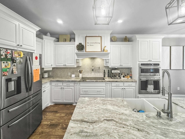 kitchen with appliances with stainless steel finishes, white cabinetry, and decorative backsplash