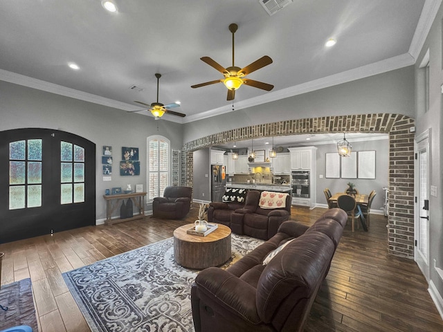 living room with dark wood-style floors, ornamental molding, and visible vents