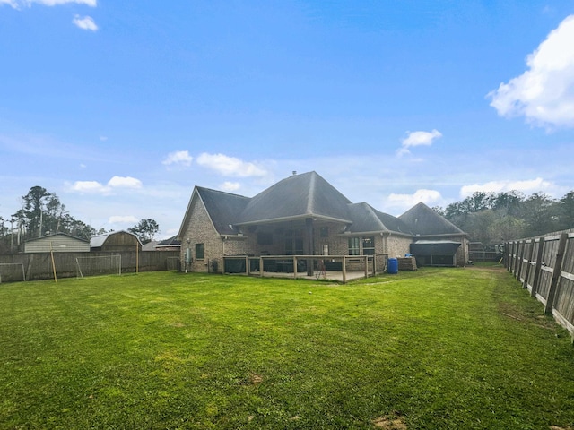 rear view of property with a yard, brick siding, and a fenced backyard