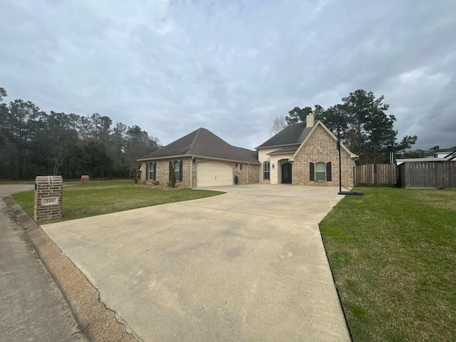 french country style house featuring driveway, a garage, fence, a front yard, and brick siding