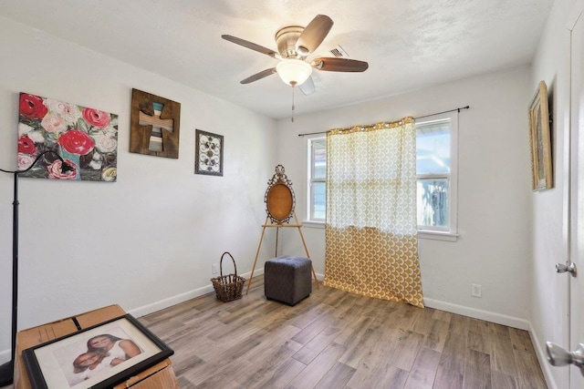 interior space with ceiling fan, baseboards, and wood finished floors