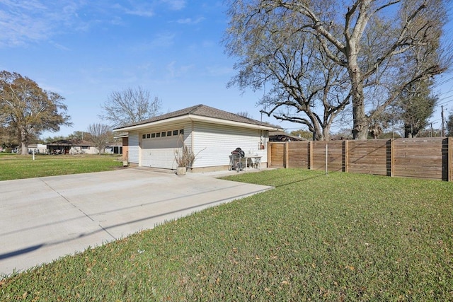 view of home's exterior featuring an attached garage, a lawn, fence, and driveway