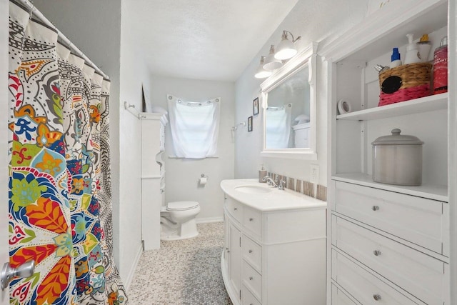 full bathroom featuring toilet, vanity, and baseboards