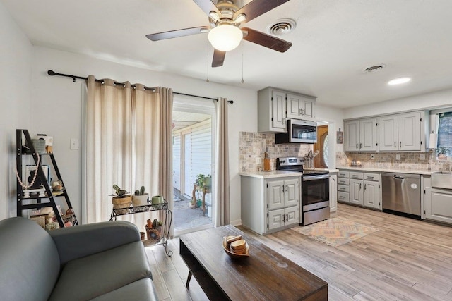 kitchen featuring visible vents, appliances with stainless steel finishes, gray cabinetry, and light countertops