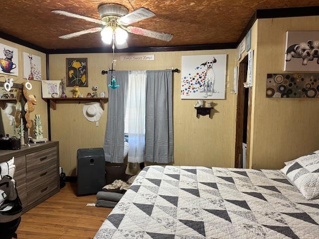 bedroom with hardwood / wood-style floors, ceiling fan, wooden ceiling, and crown molding