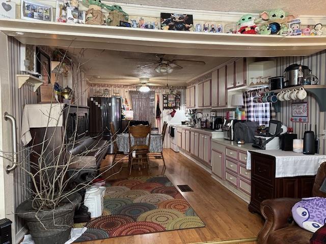 kitchen with dark brown cabinetry, light hardwood / wood-style floors, and ceiling fan