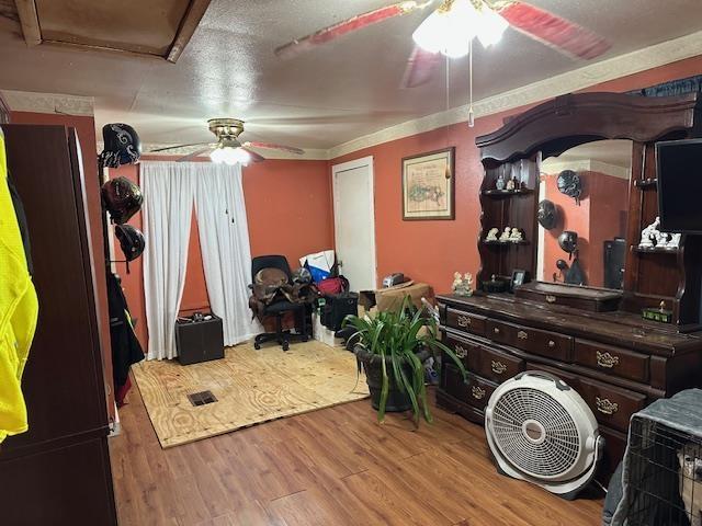 bedroom with ceiling fan, crown molding, and hardwood / wood-style flooring