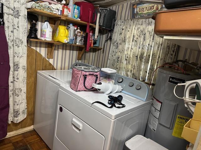 laundry room with washer and clothes dryer, dark parquet flooring, and water heater