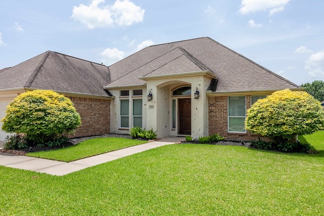 3665 Canyon Ln, Beaumont, TX 77713 - view of front facade featuring brick siding, a front lawn, a shingled roof, and an attached garage