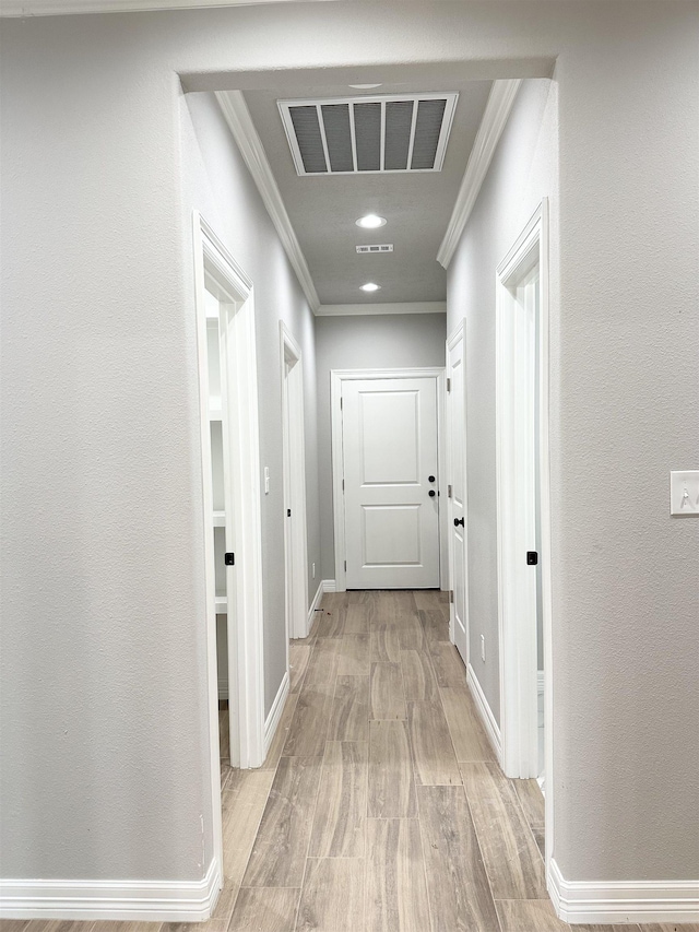 hall featuring ornamental molding and light hardwood / wood-style flooring